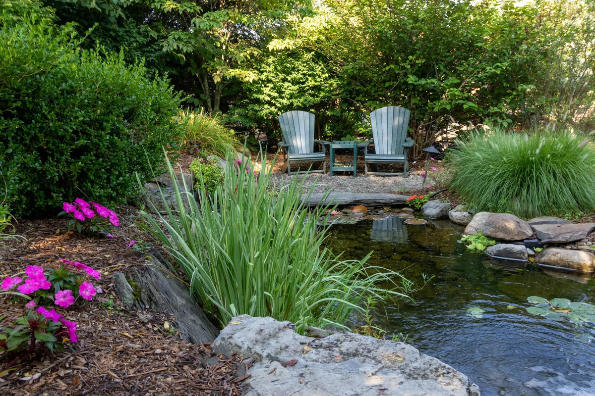 Fish Pond with chairs surrounded by greenery and flowers img for home page 